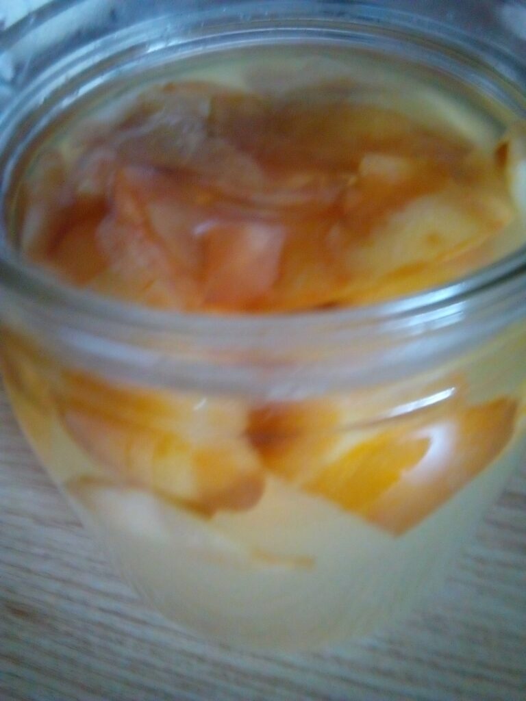 Golden homemade apple cider vinegar glowing in the sunlight