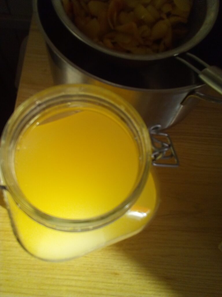 Golden apple cider liquid in a glass jar before second fermentation