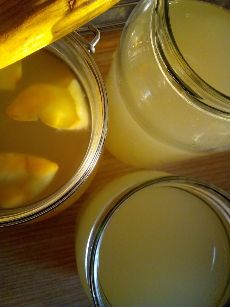 Pouring golden homemade apple cider vinegar into glass bottle