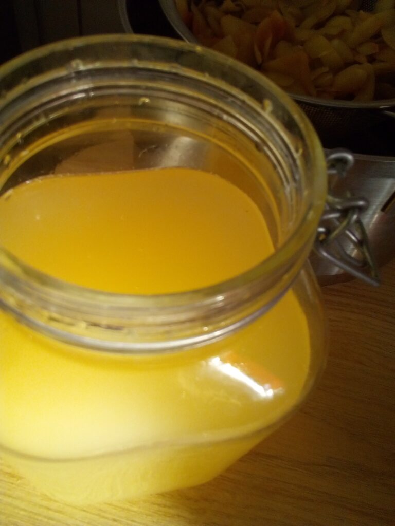 Glass jar filled with apples for starting apple cider vinegar fermentation