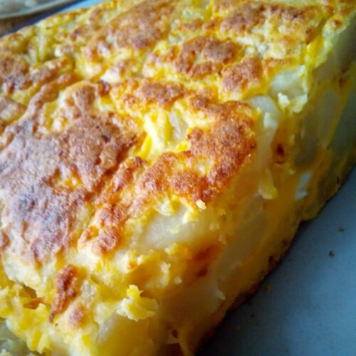 Authentic Spanish tortilla recipe cooked in a non-stick skillet – traditional Spanish food with potatoes and eggs.