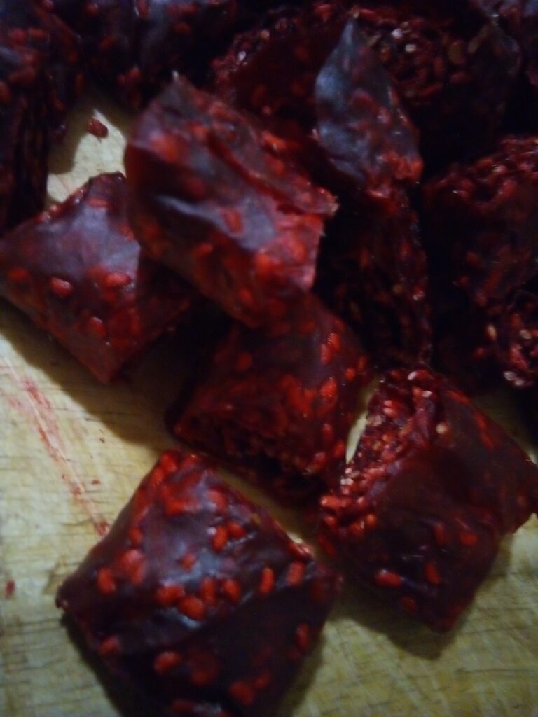 Child holding a strip of homemade raspberry fruit leather as a healthy snack.