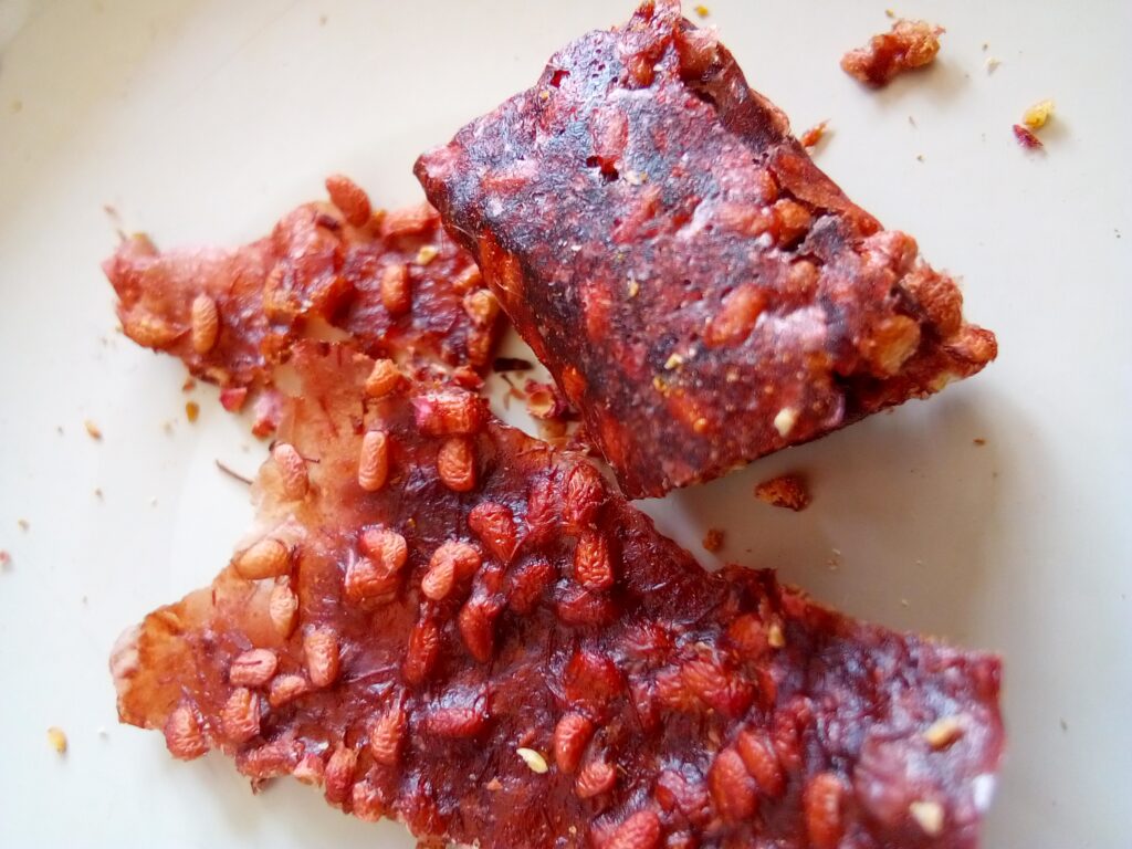 Homemade fruit leather rolls sealed in glass jars stored in a cool, dark pantry.