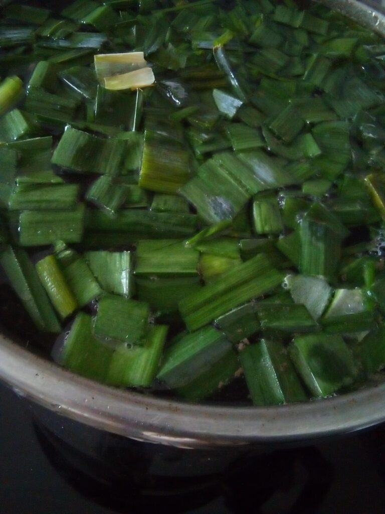 Frozen leeks being added straight into hot broth during soup cooking demonstrating an easy method for using preserved garden vegetables.