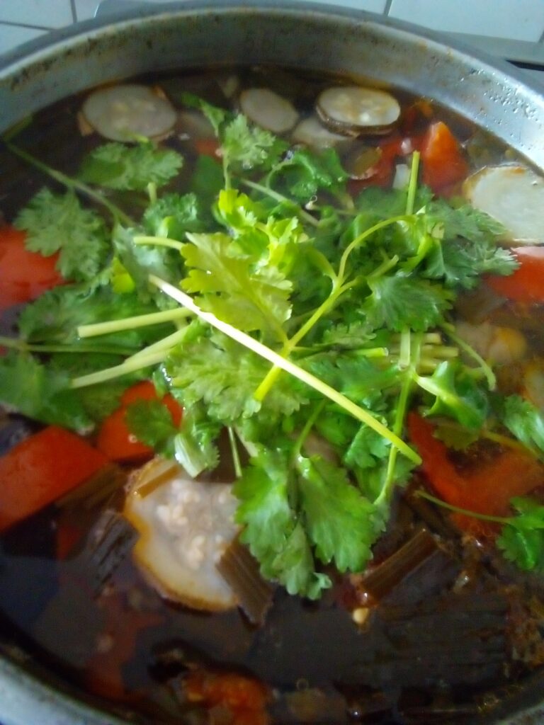Beef soup simmering gently in a large pot with vegetables and bones creating a clear and nourishing broth cooked low and slow.