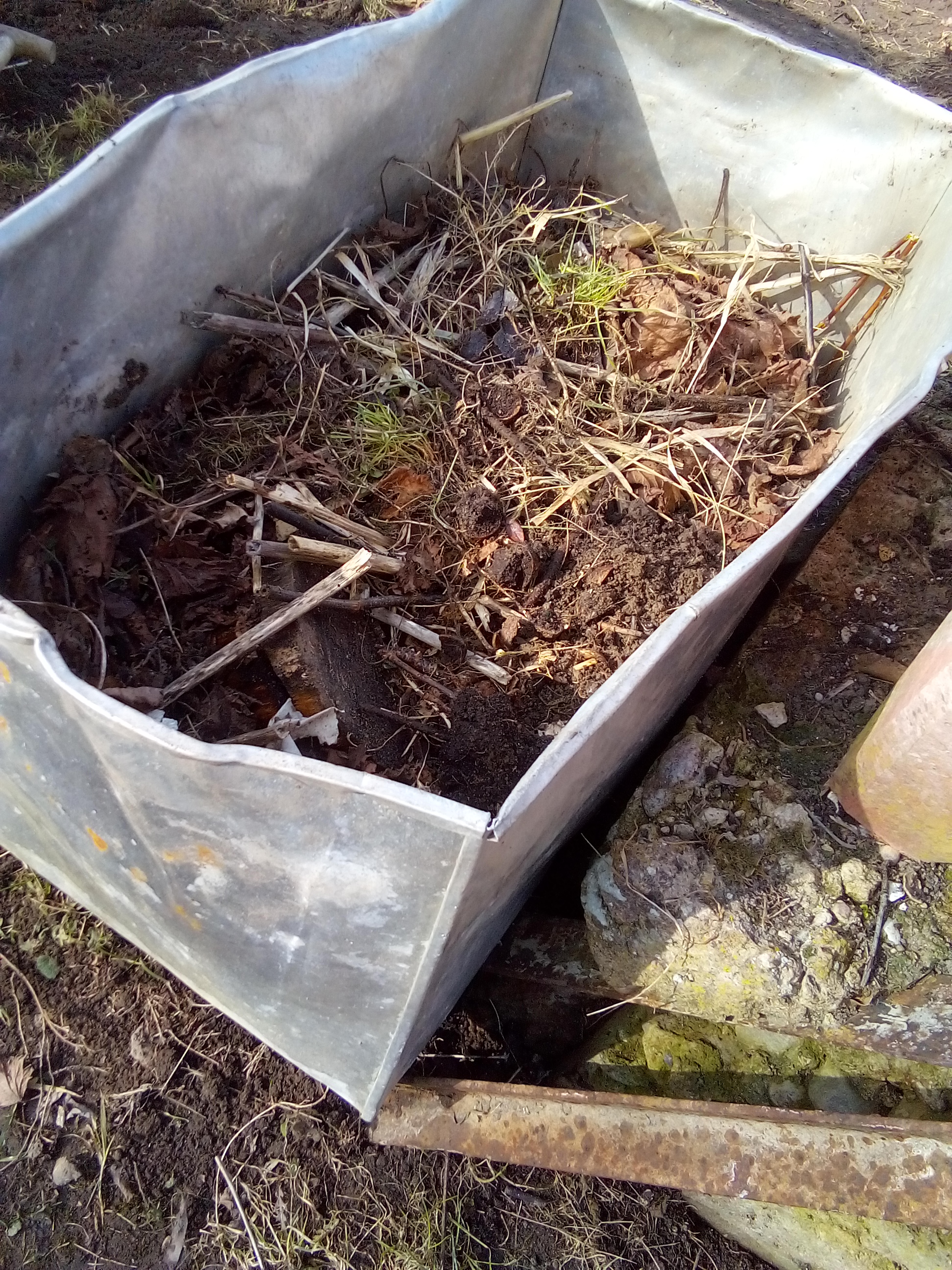 : Organic compost added to raised garden beds to enrich soil and support vegetable growth.