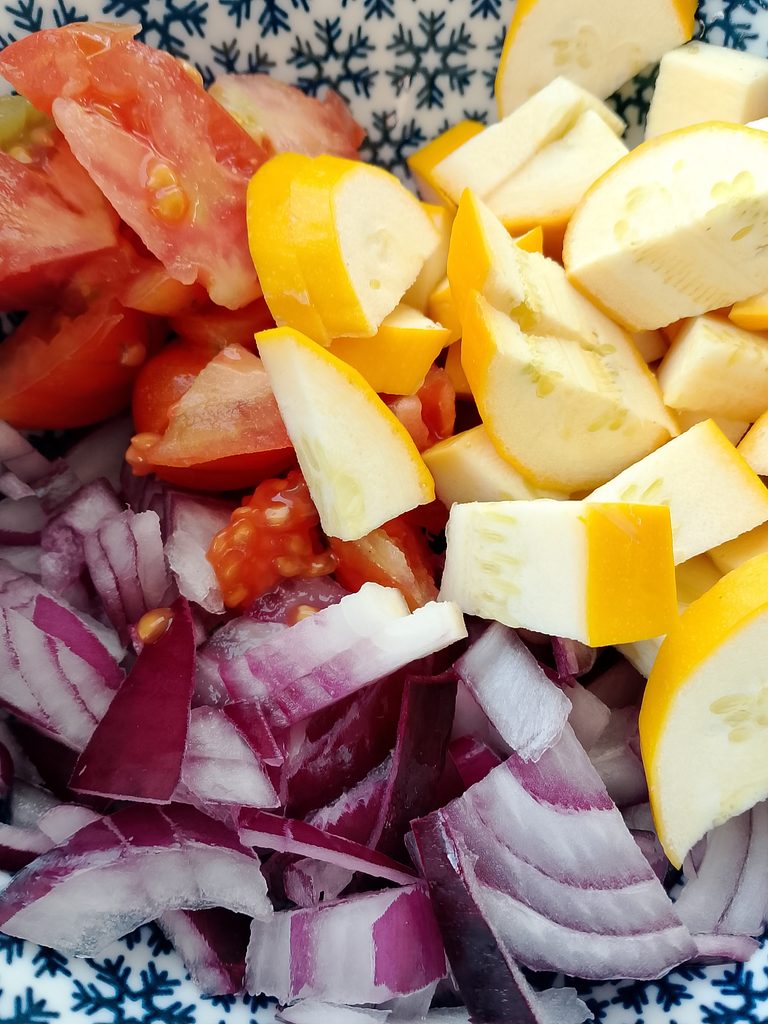 Busy mom cooking a fresh home-office lunch with zucchini and tomato